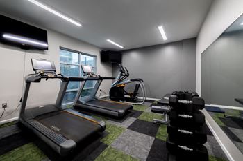 a gym with treadmills and other exercise equipment in a building at 310 at Nulu Apartments-Student, Louisville, 40202